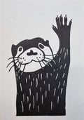 Detailed view of the hand-printed black ink texture on the Waving Otter lino print.