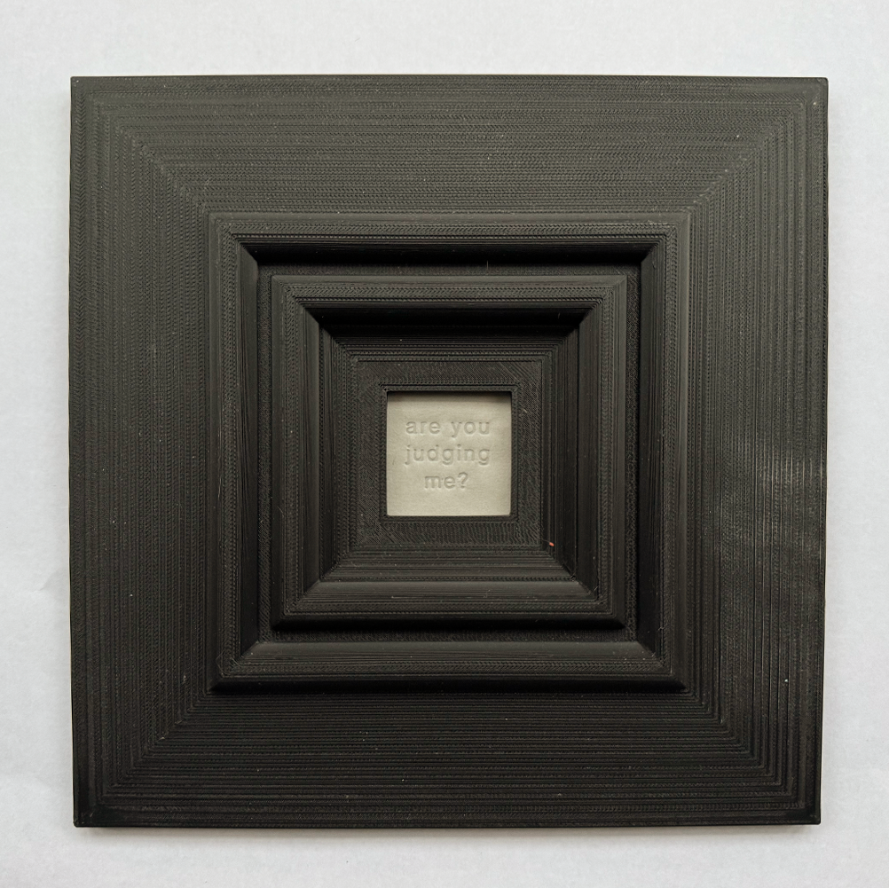 Original, minimalist, hand-embossed grey art card featuring the fun message ‘are you judging me?’ demonstrating the scale of the black oversized 3d printed frame