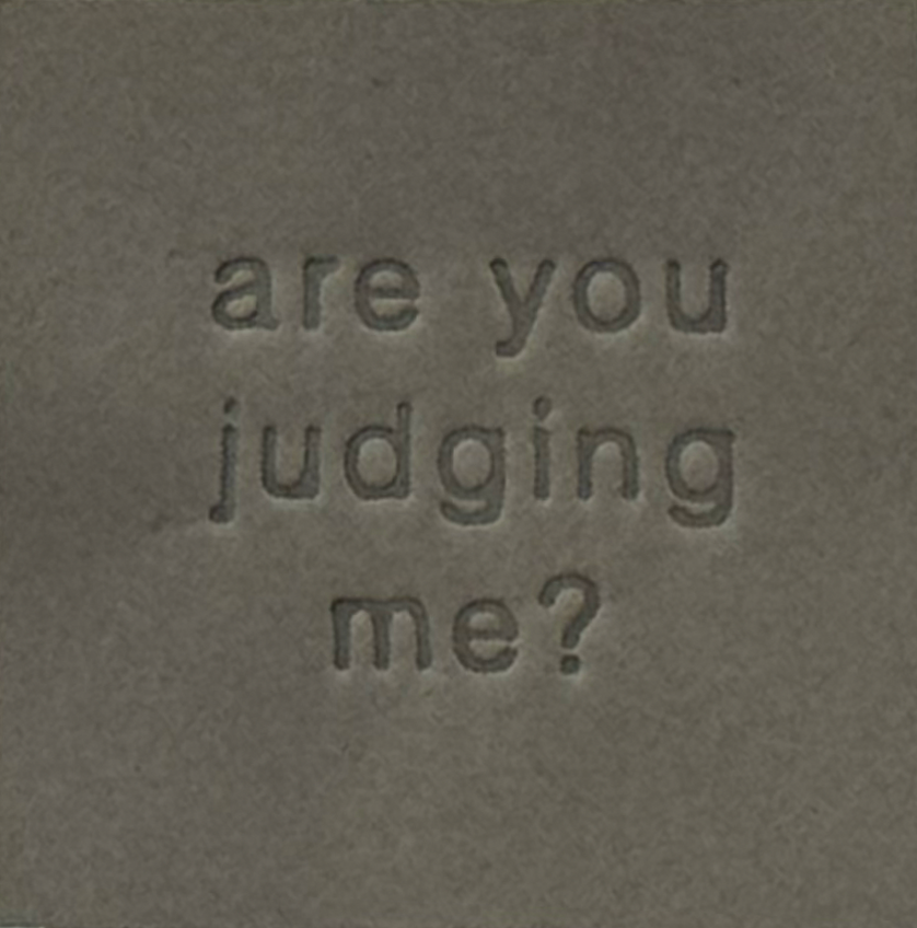 Surface Detail of original, minimalist, hand-embossed grey art card featuring the fun message ‘are you judging me?’