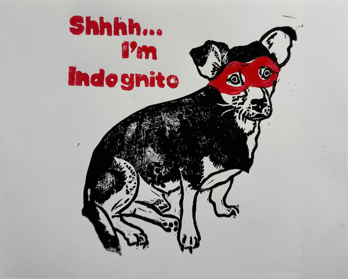 Close-up of a hand-printed two-colour linocut featuring a small dog in a red eye mask.