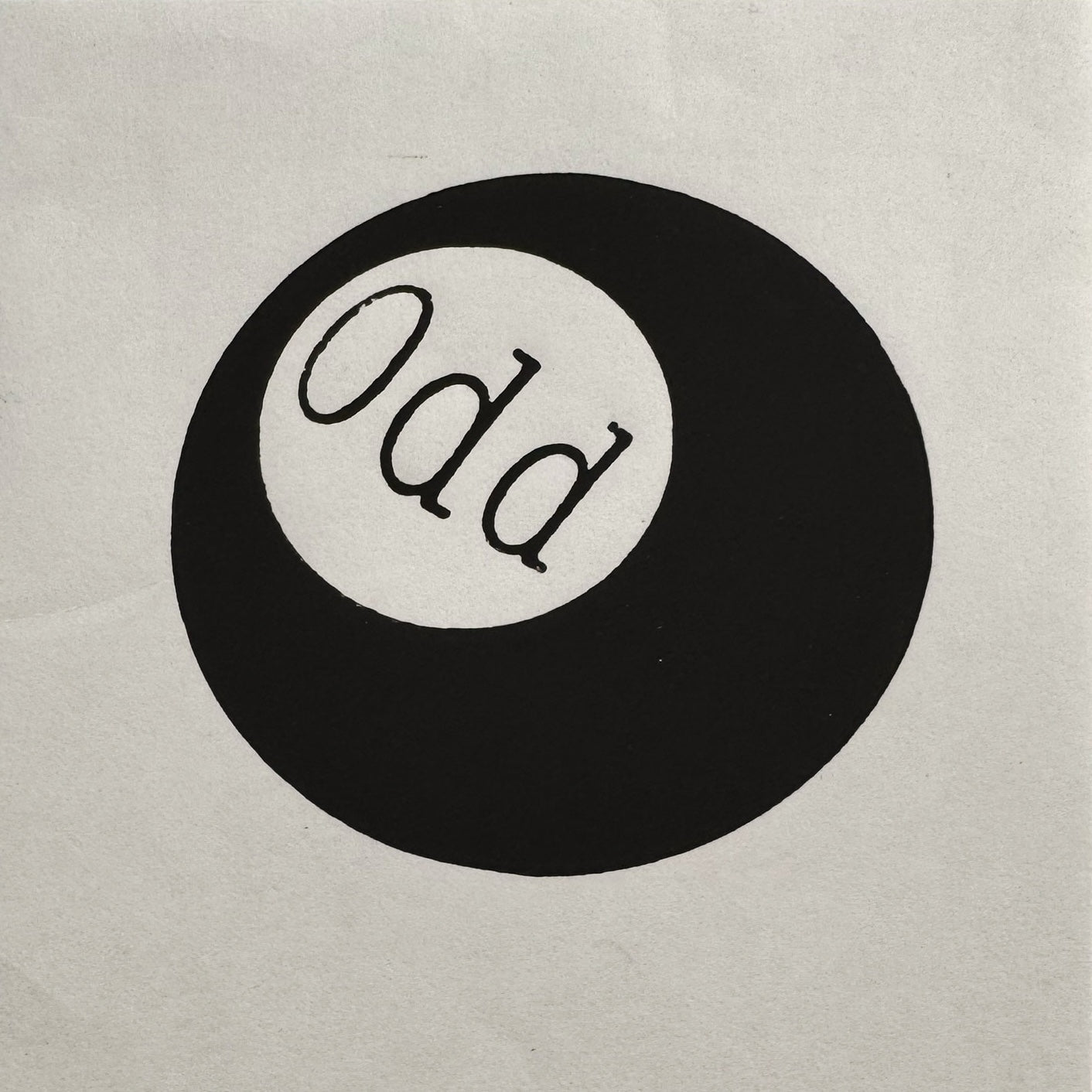 Detailed texture of a hand-printed black relief print featuring an 'Odd' pool ball.